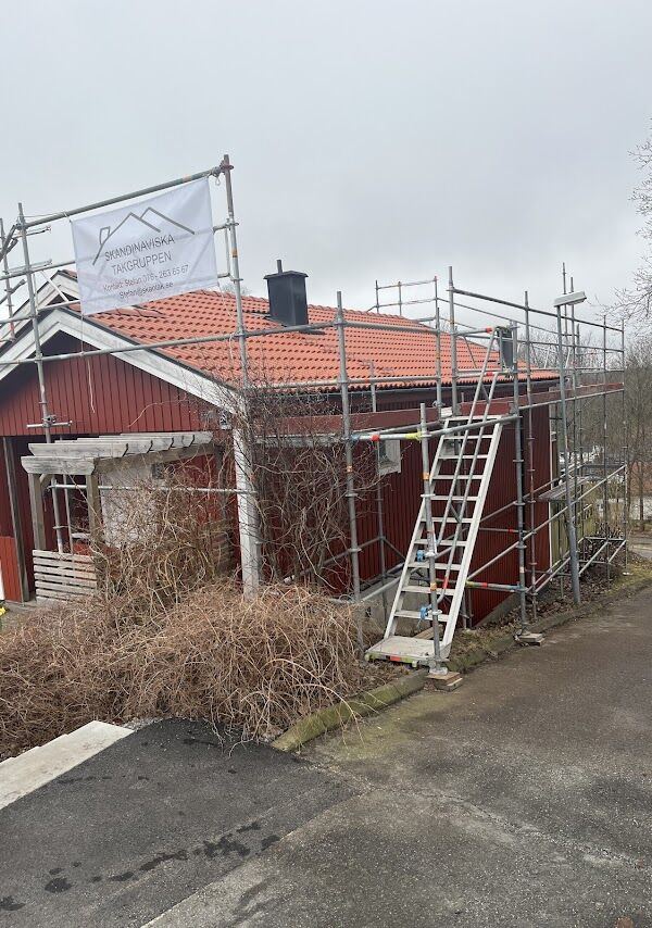 Skandinaviska Takgruppen på plats vid ett takbyte – ställning med företagets banner och nytt tegeltak